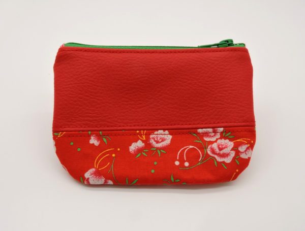 Devant du porte monnaie en simili cuir rouge et en coton "Petit Pan" rouge à fleurs roses et vertes.